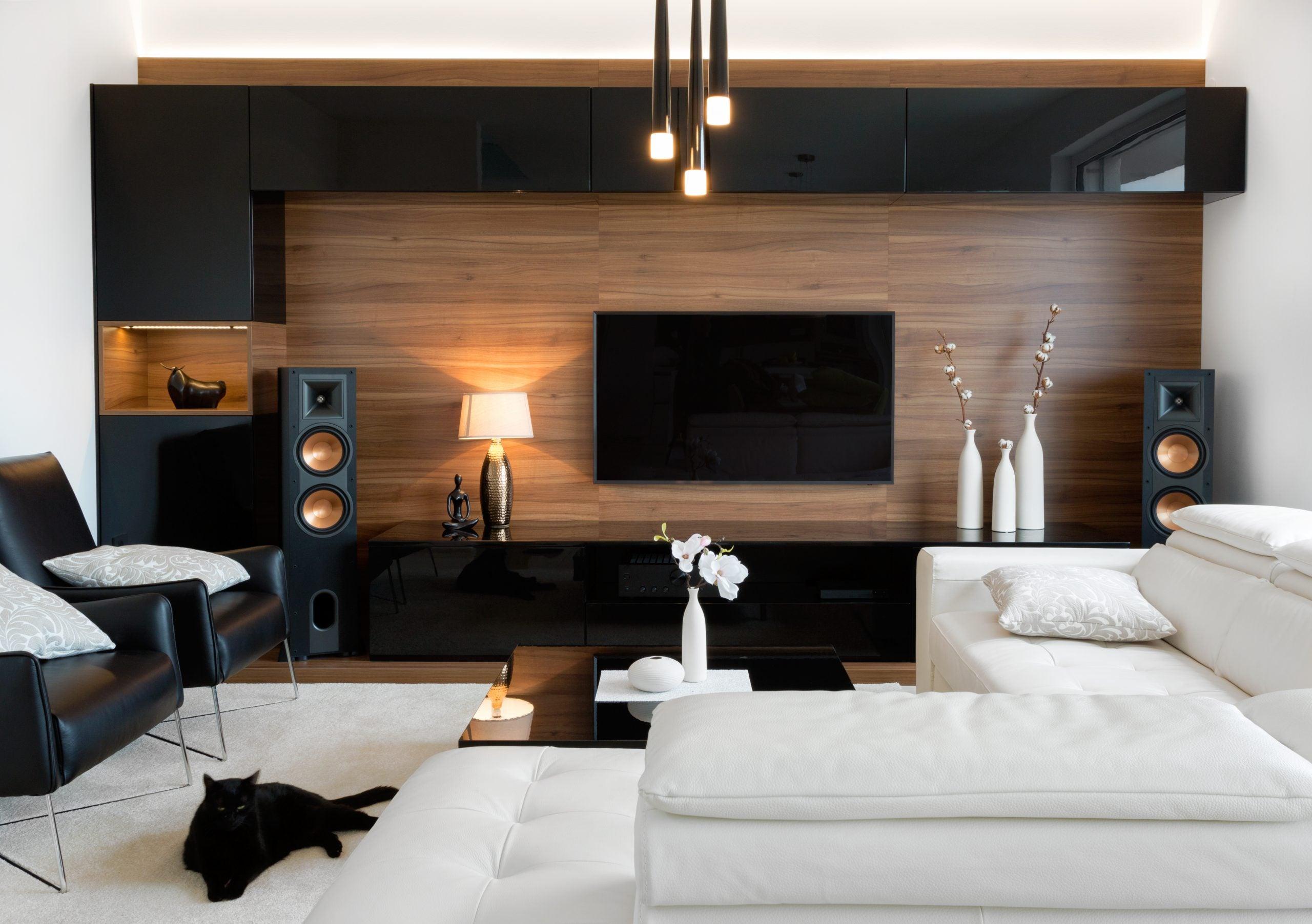 A black cat relaxing in a spacious, modern living room.